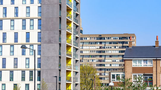 A modern apartment block in front of a social housing block