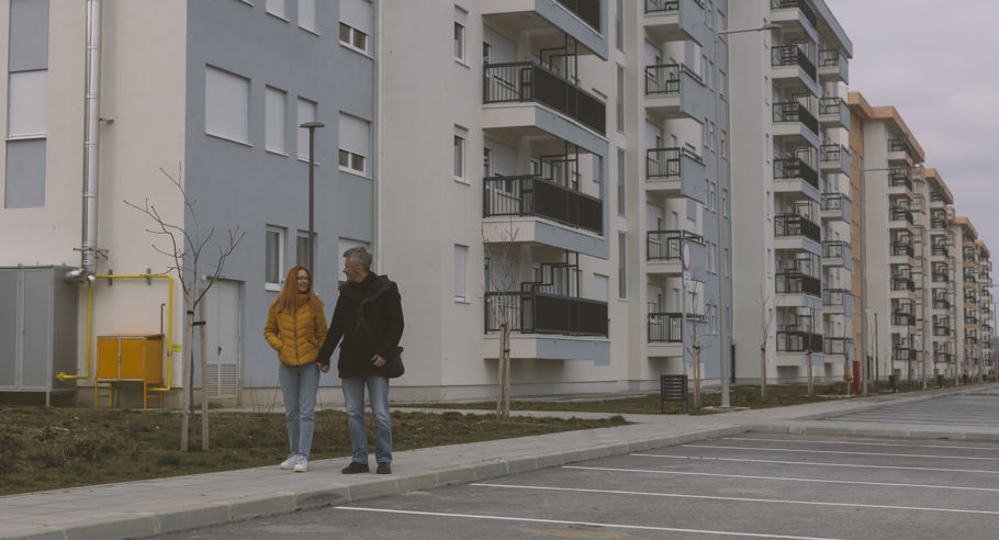 Two people holding hands next to an apartment complex